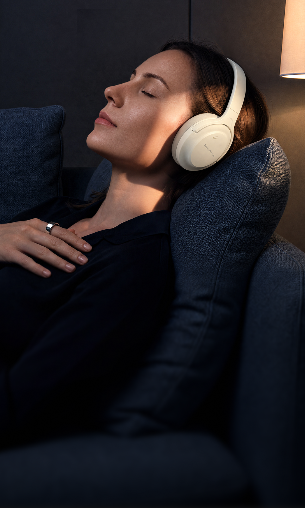 Woman relaxing in a chair while wearing Polar White DreamPhones