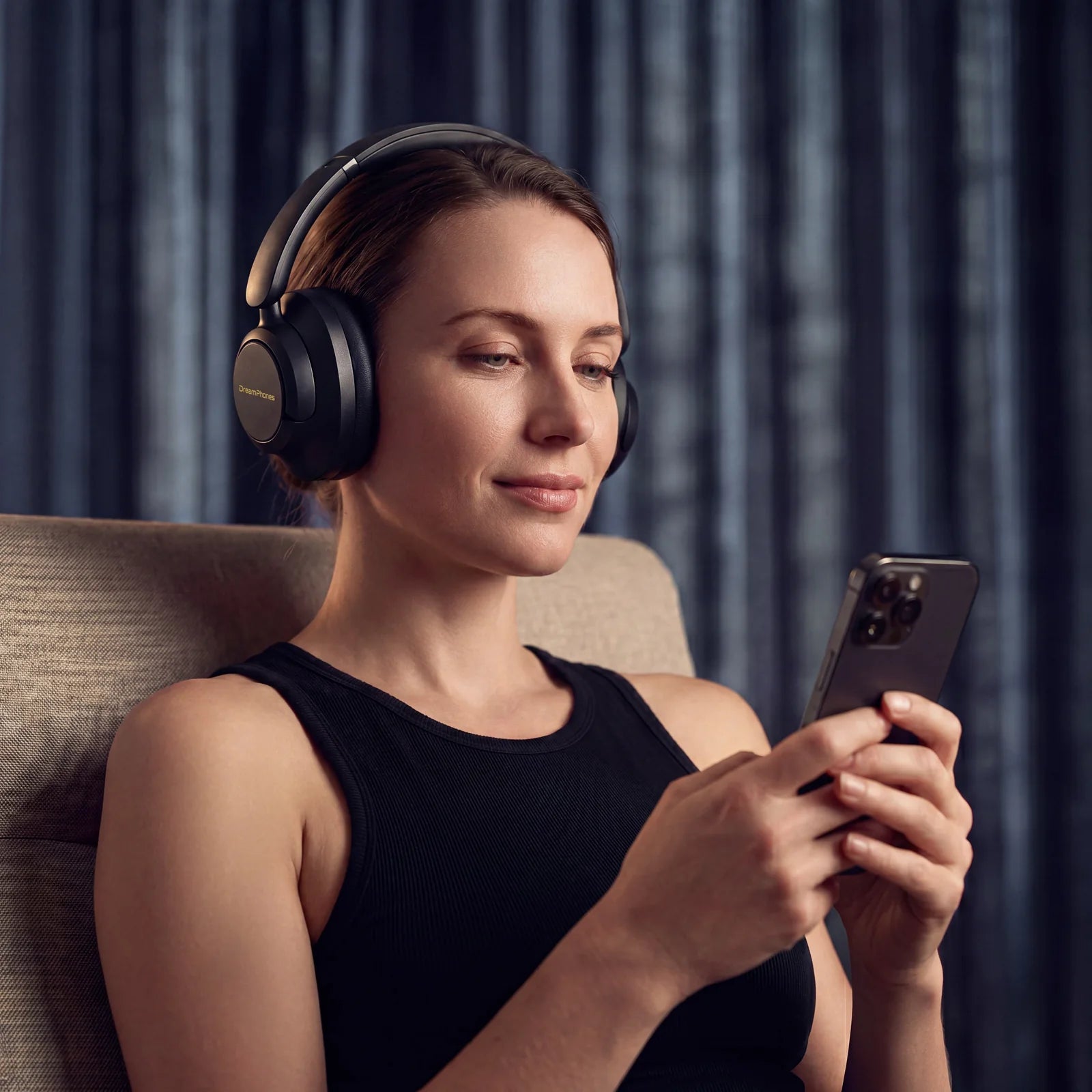 Woman using the DreamPhones app while wearing Obsidian Black DreamPhones